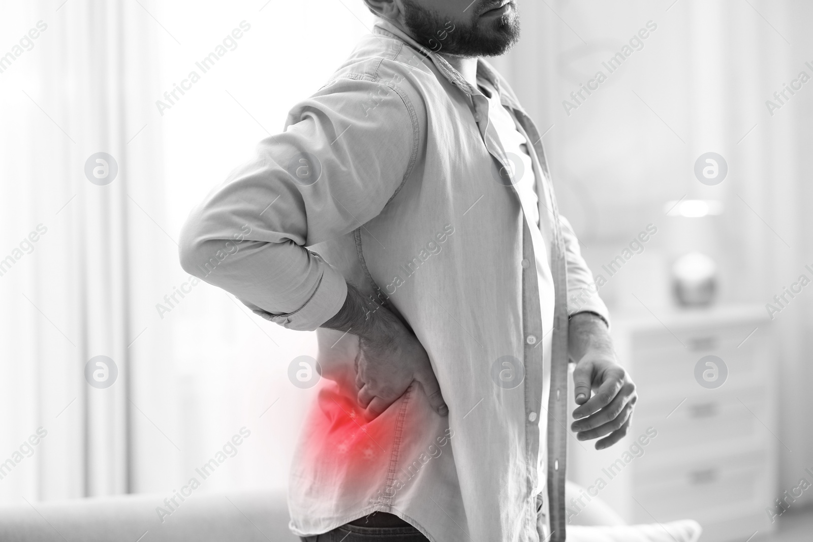 Image of Man suffering from back pain at home, closeup. Bad posture problem