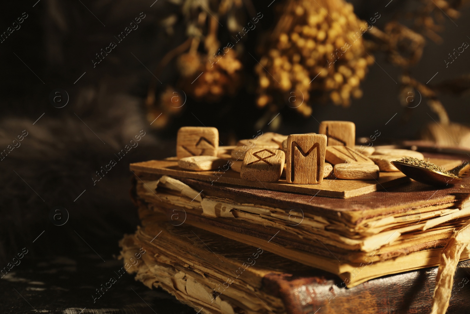 Photo of Many wooden runes and old books on altar, closeup. Space for text