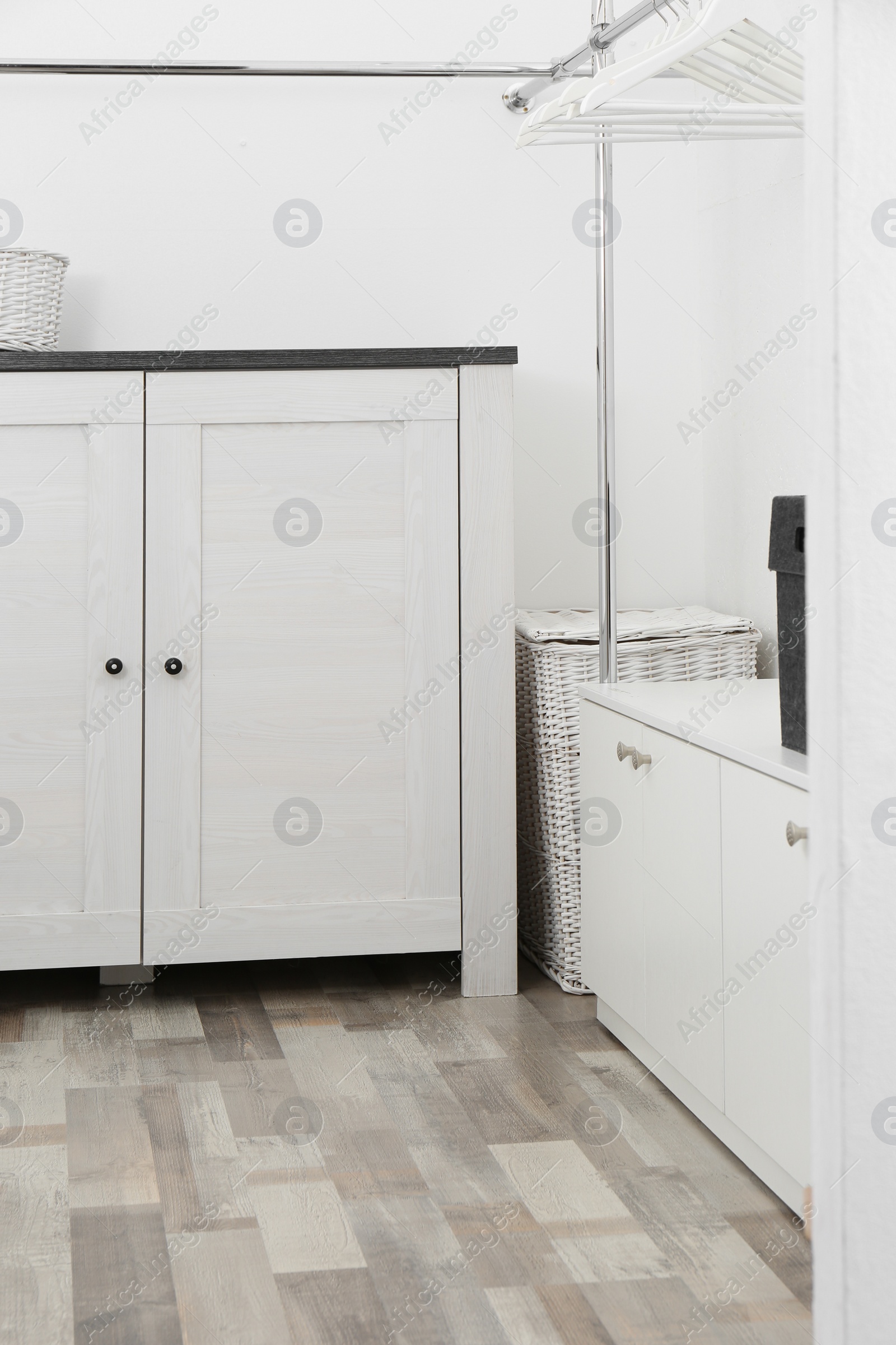 Photo of Dressing room with chest of drawers and rack for clothes