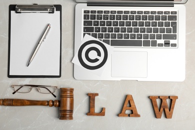 Photo of Flat lay composition with clipboard, gavel and laptop on grey background. Copyright law concept