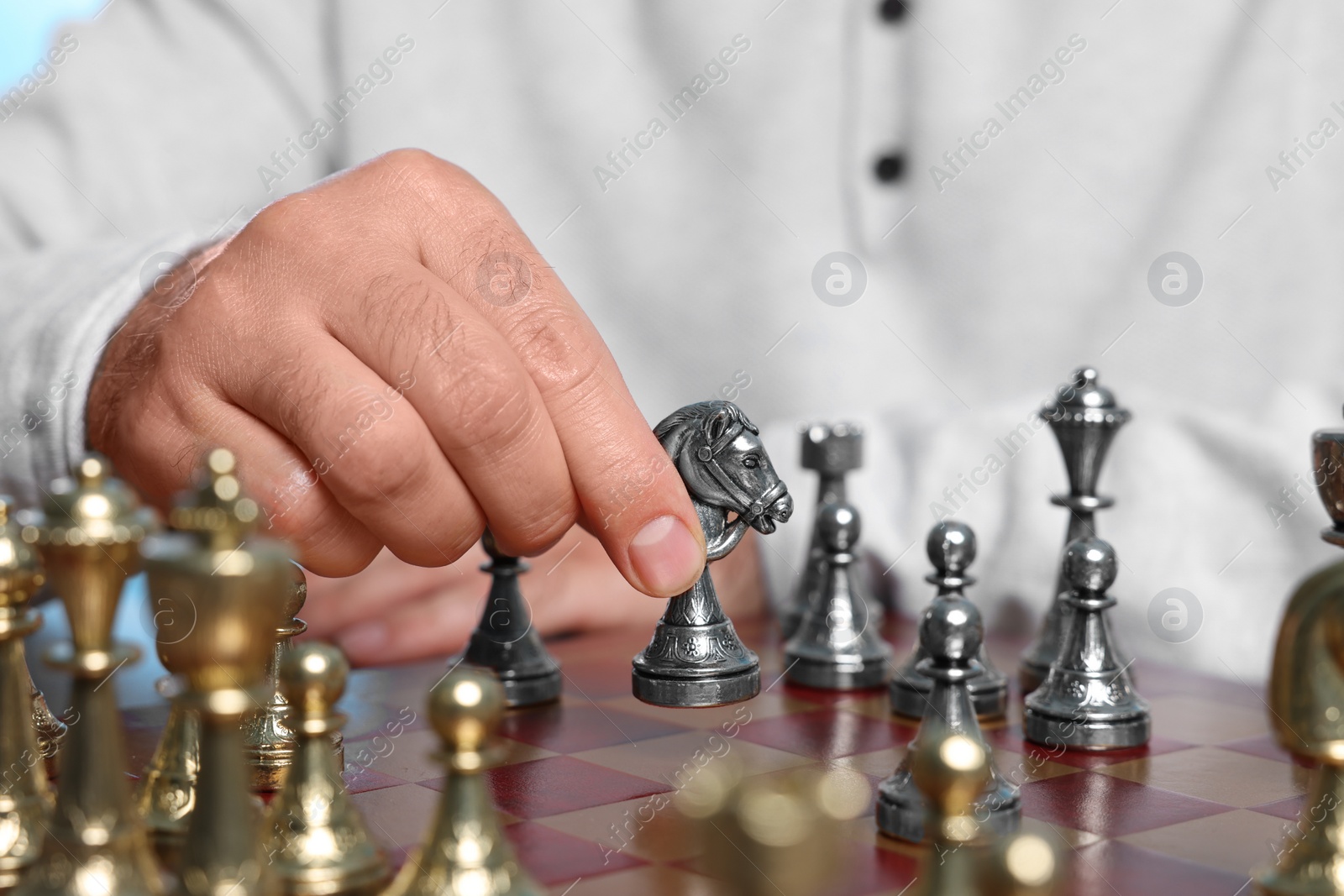 Photo of Man with knight playing chess at checkerboard, closeup