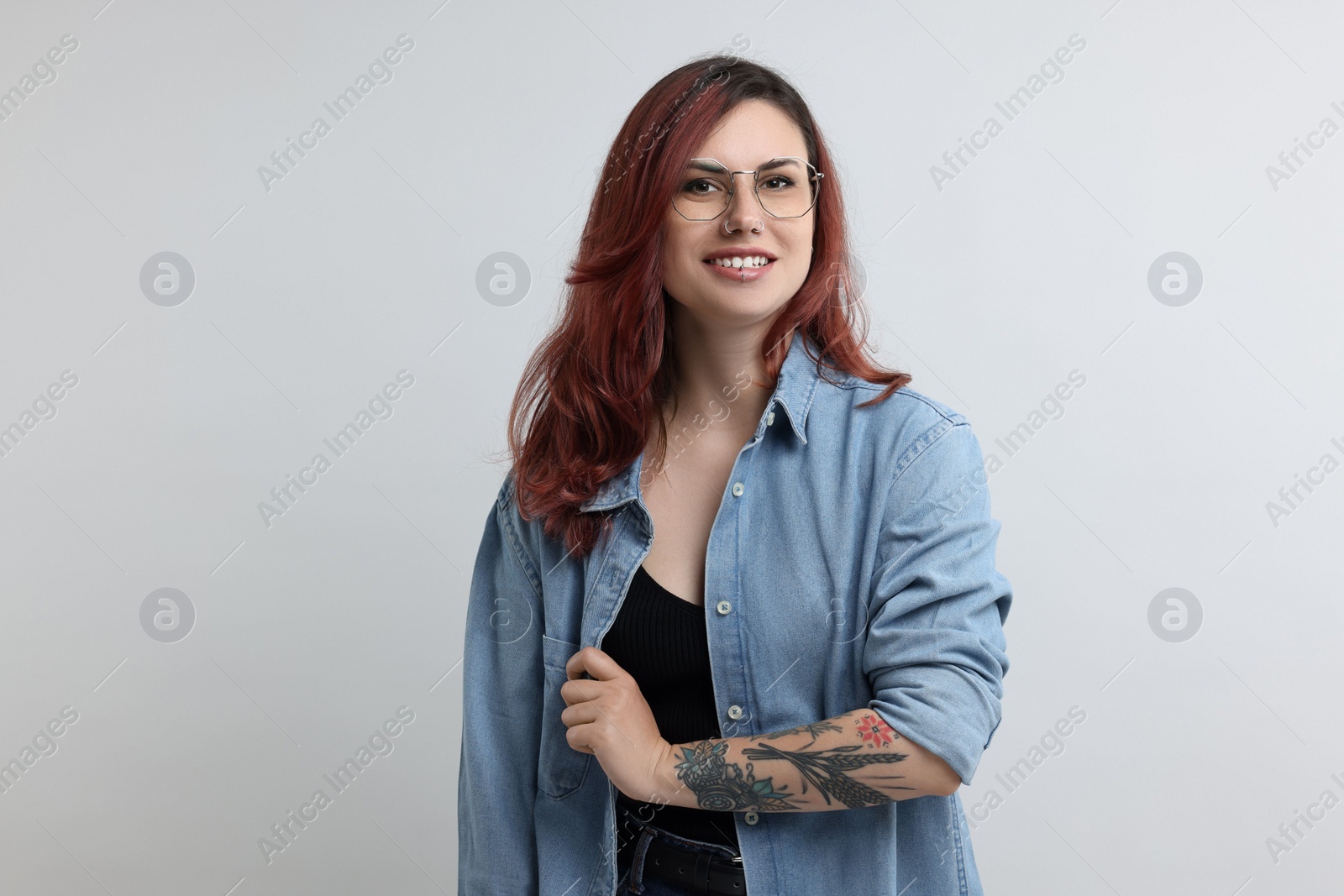 Photo of Portrait of beautiful tattooed woman on gray background