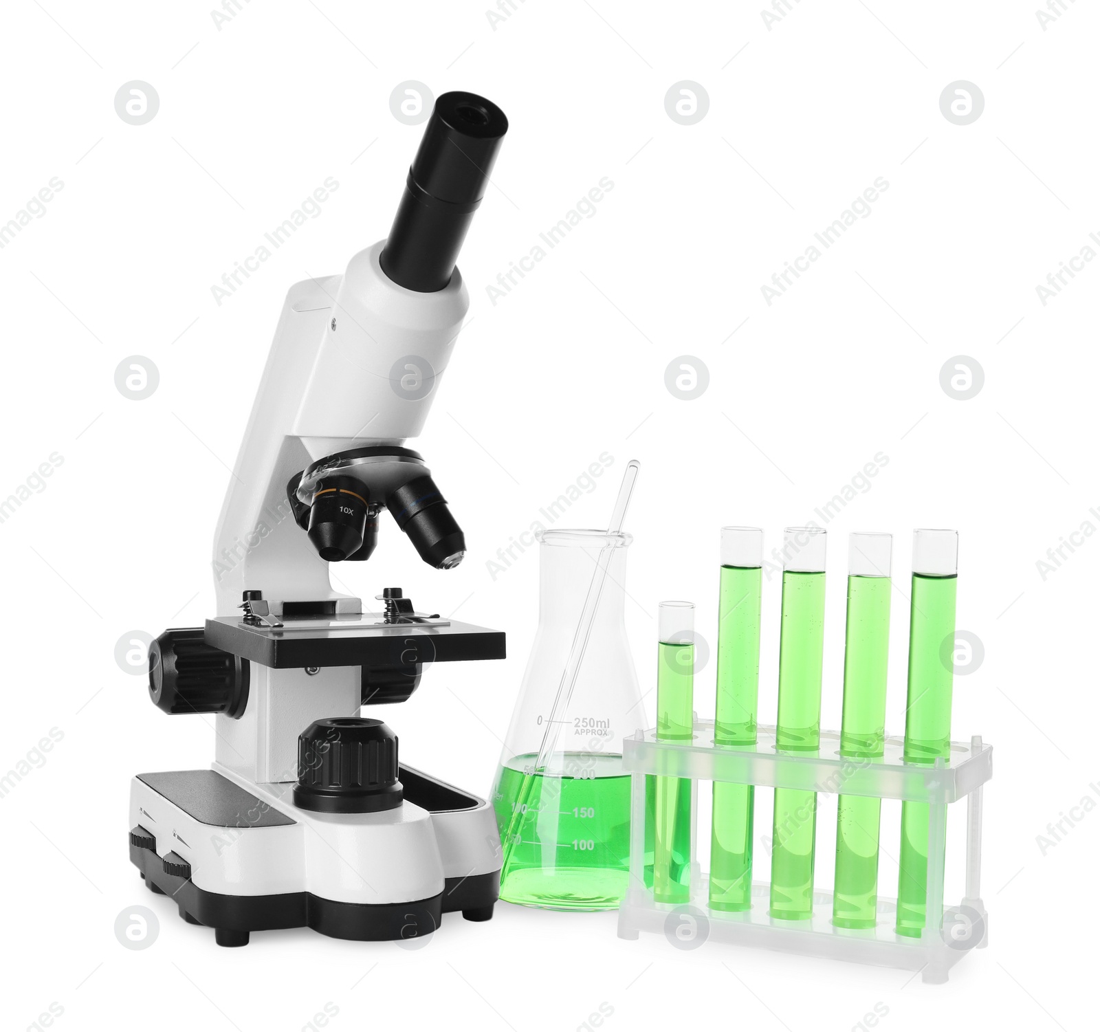 Photo of Laboratory glassware with green liquid and microscope isolated on white