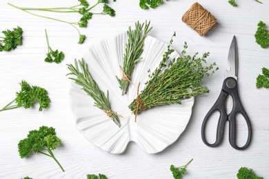 Flat lay composition with rosemary on wooden background. Aromatic herbs