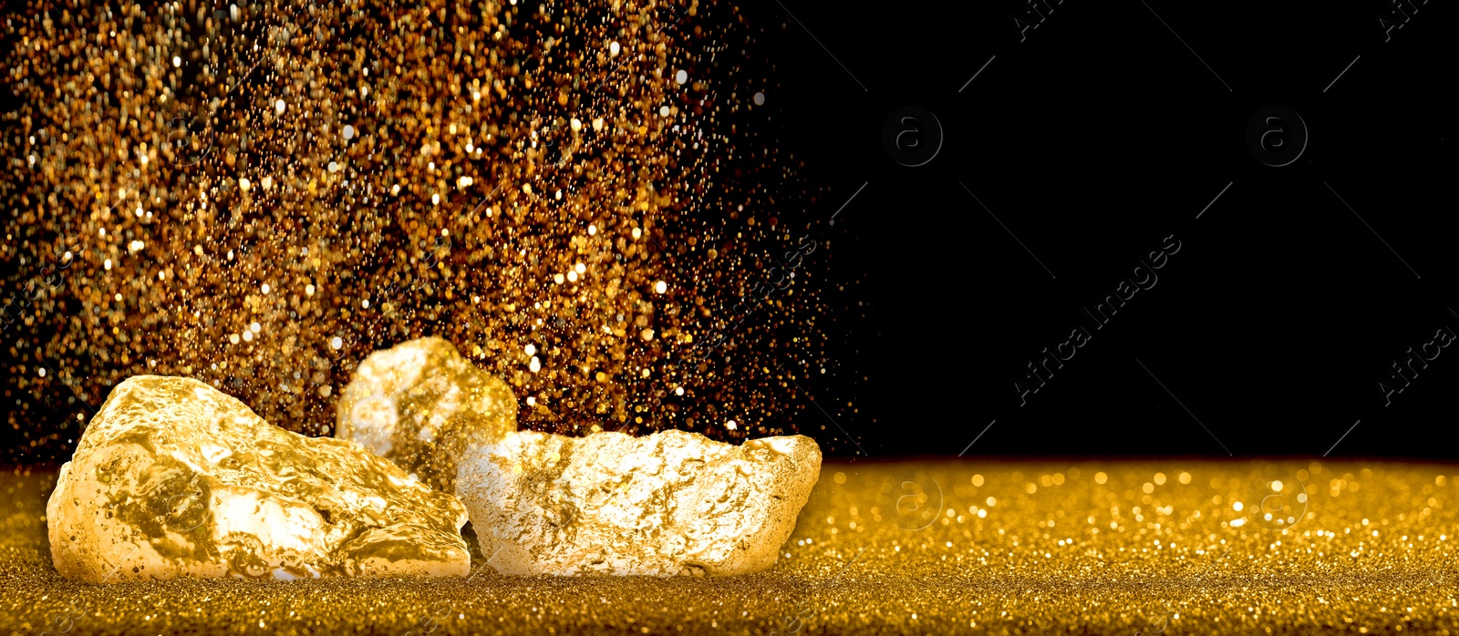 Image of Gold dust falling on gold nuggets against black background. Banner design with space for text