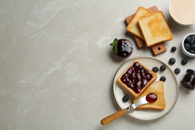 Photo of Toasts, blueberry jam and cup of coffee served on light marble table, flat lay. Space for text