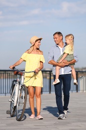 Photo of Happy family with bicycle outdoors on sunny day