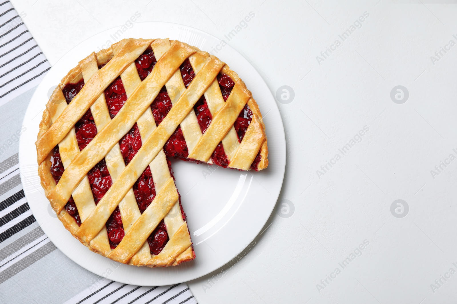 Photo of Delicious fresh cherry pie on white table, top view. Space for text