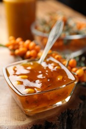 Photo of Delicious sea buckthorn jam and fresh berries on wood