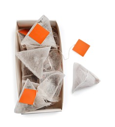 Photo of Paper tea bags with tags and box on white background, top view