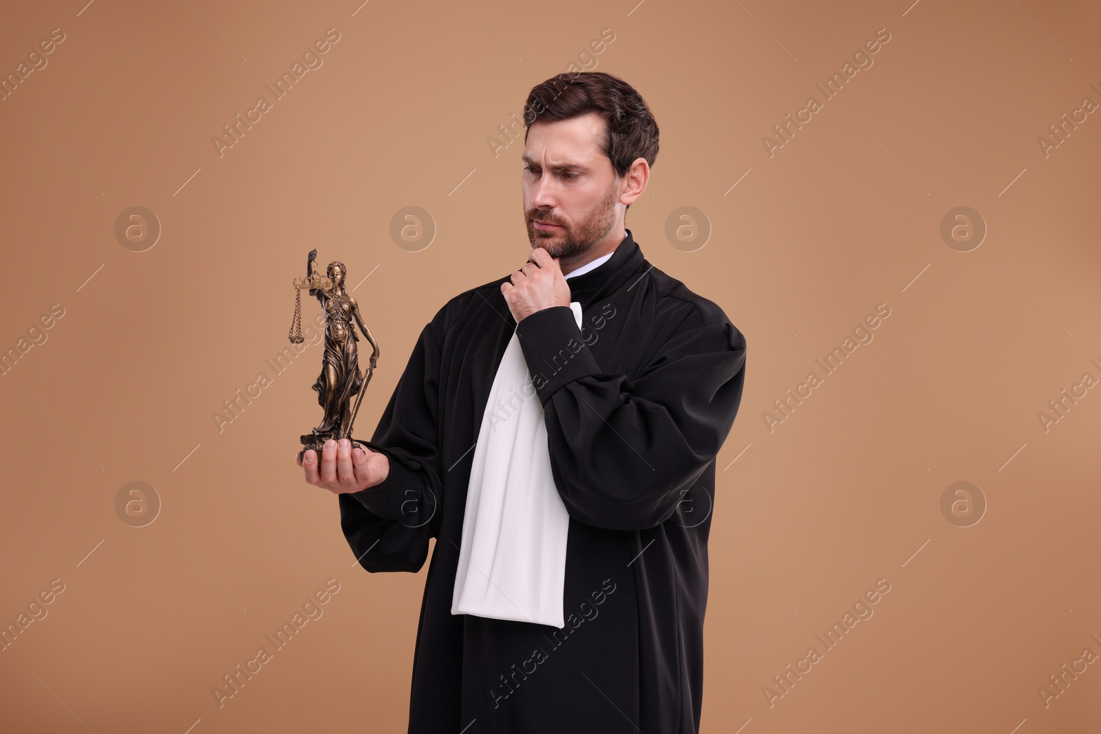 Photo of Judge with figure of Lady Justice on light brown background
