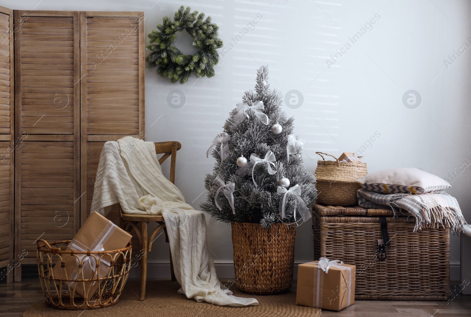 Photo of Stylish room interior with beautiful Christmas tree near white wall