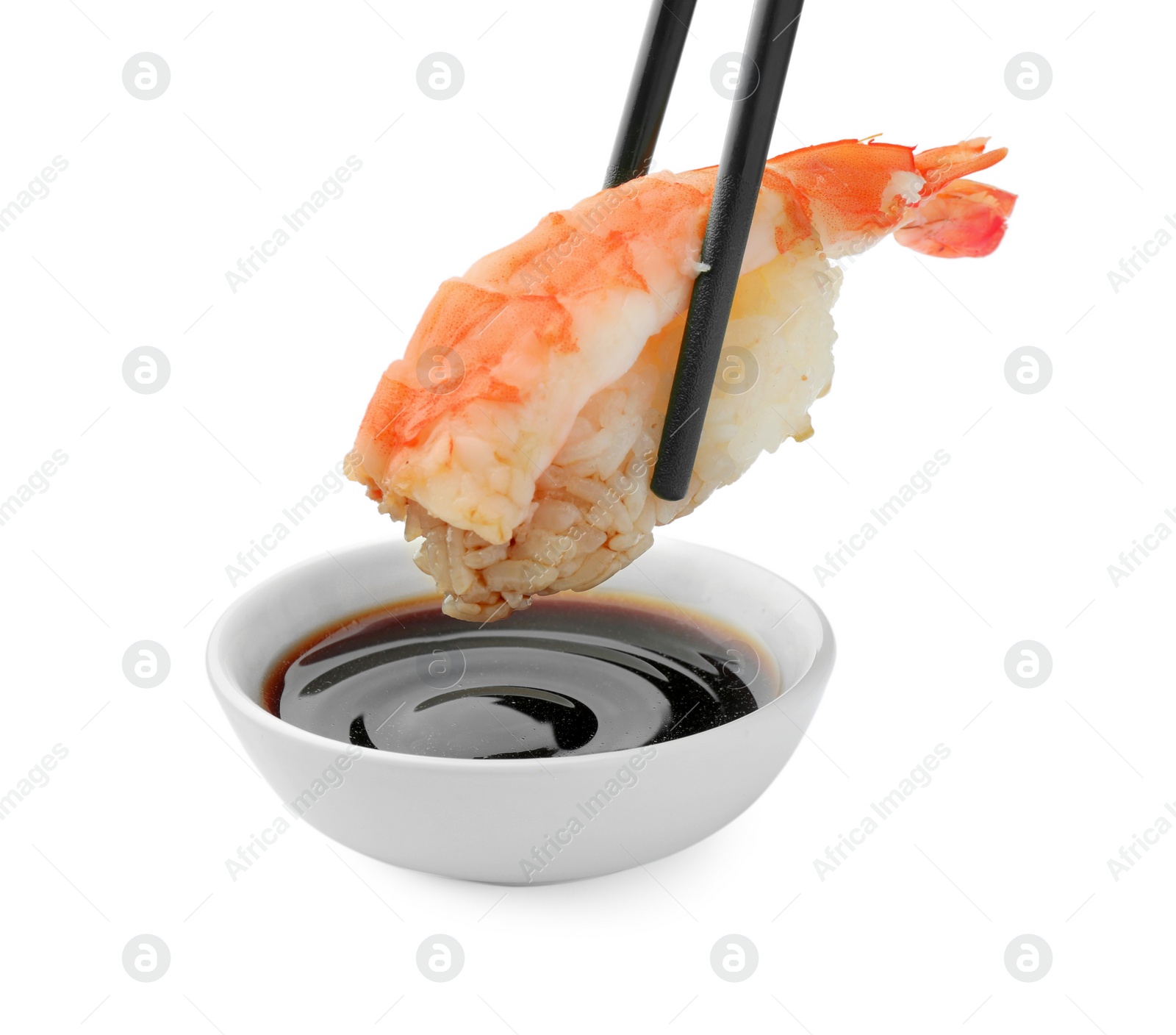 Photo of Dipping tasty sushi into soy sauce isolated on white