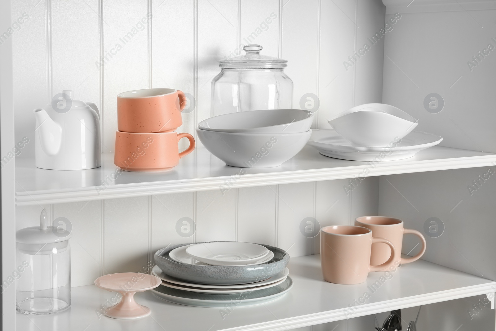 Photo of Stylish storage stand with different ceramic dishware at home