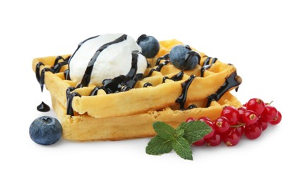 Tasty Belgian waffles with ice cream, berries and chocolate syrup on white background