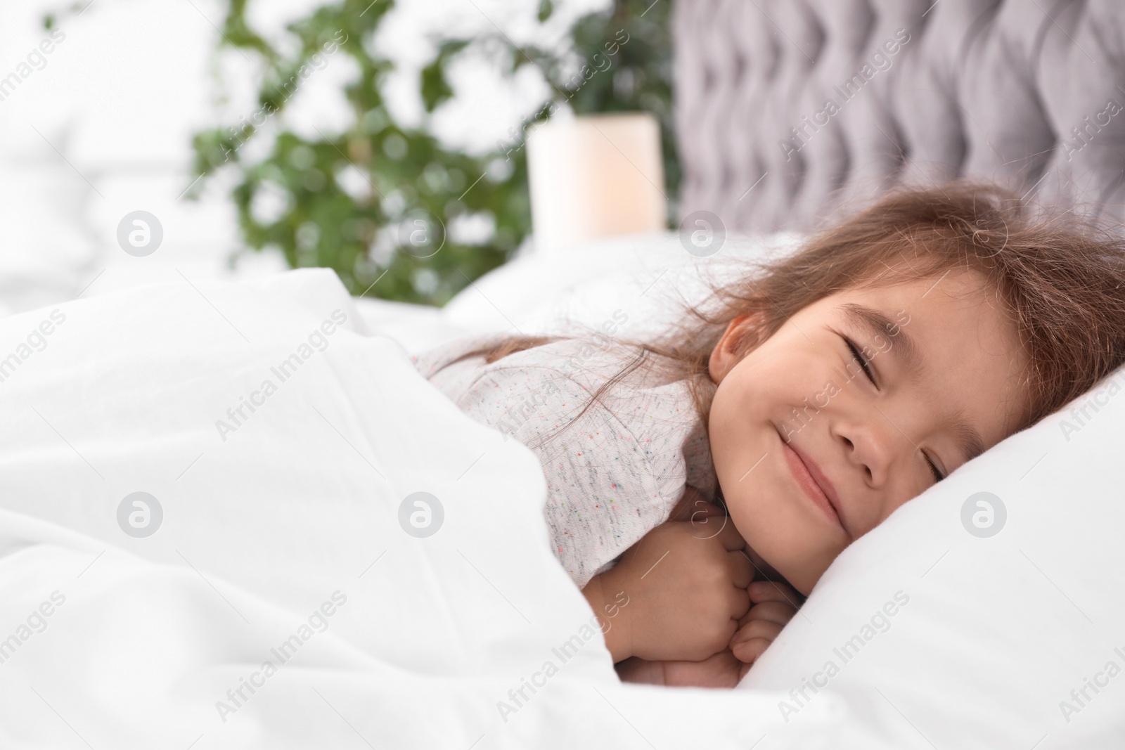 Photo of Cute little girl sleeping in cozy bed