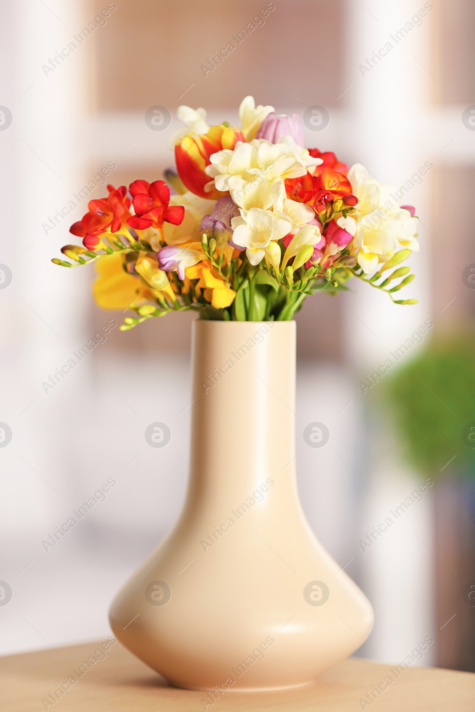 Photo of Beautiful bouquet of freesia flowers on blurred background