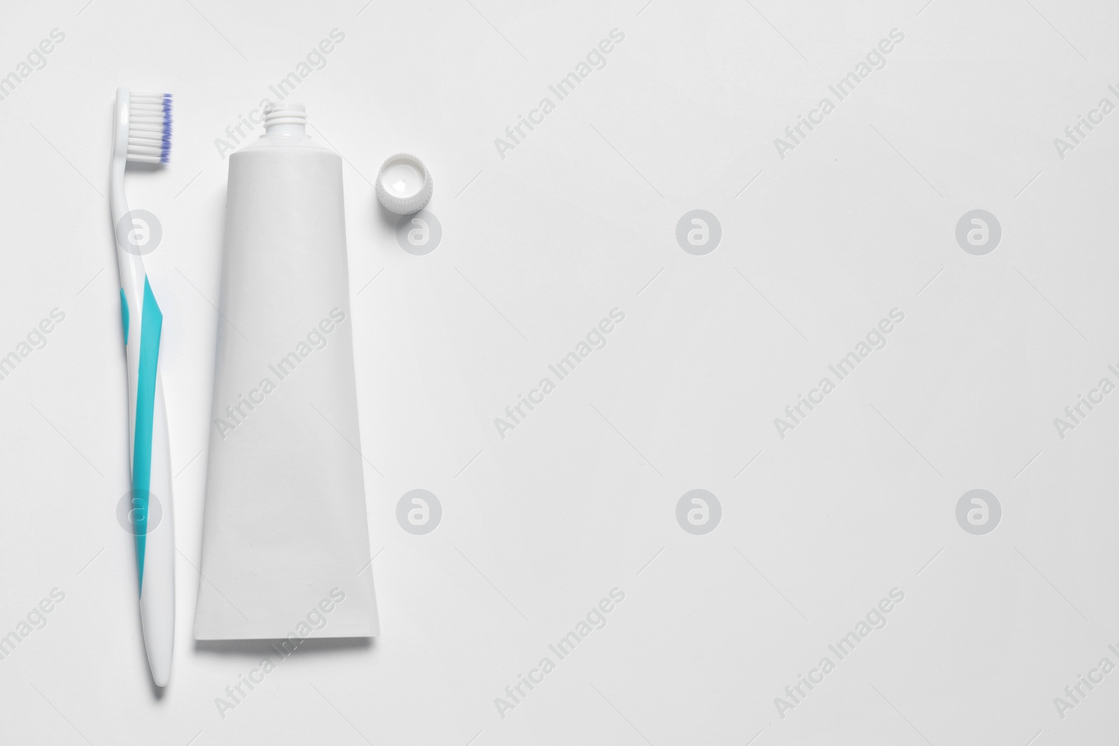 Photo of Plastic toothbrush and paste on white background, top view. Space for text