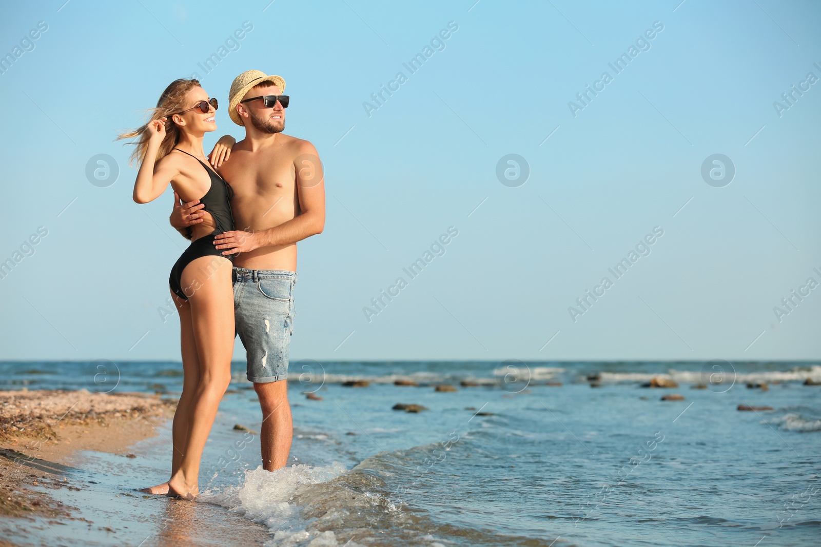 Photo of Young couple spending time together on beach