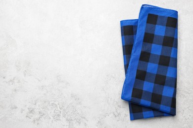 Photo of Folded blue checkered bandana on white table, top view. Space for text