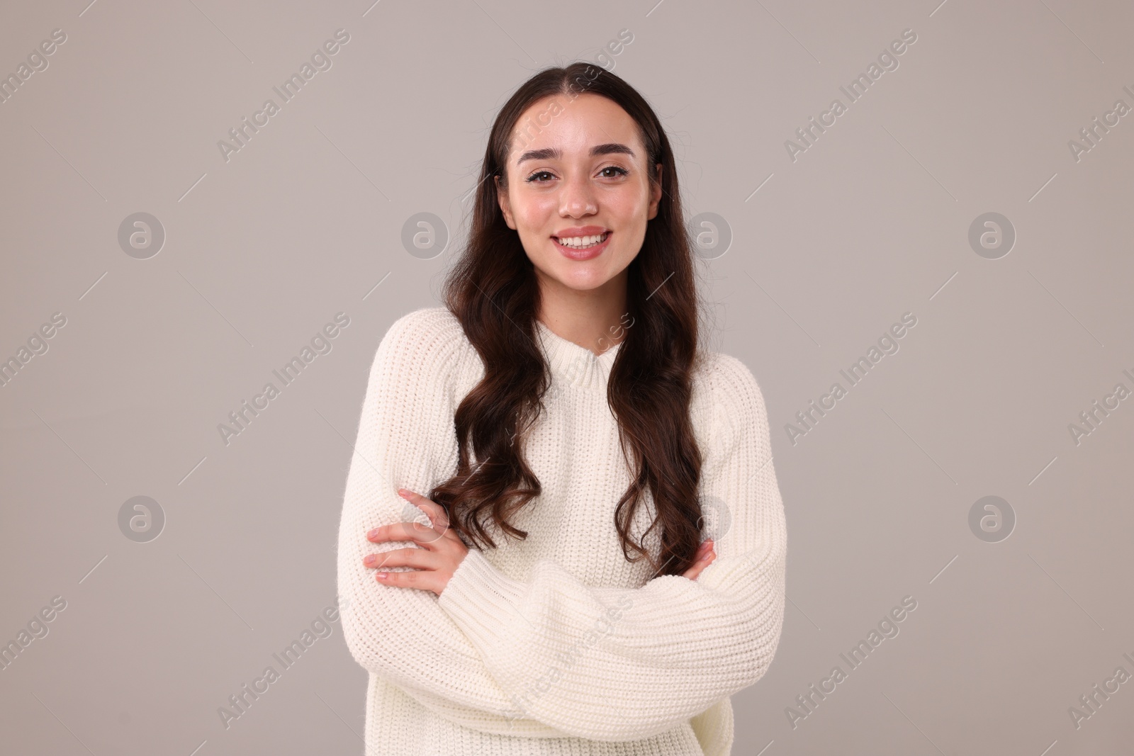 Photo of Beautiful young woman in stylish warm sweater on grey background