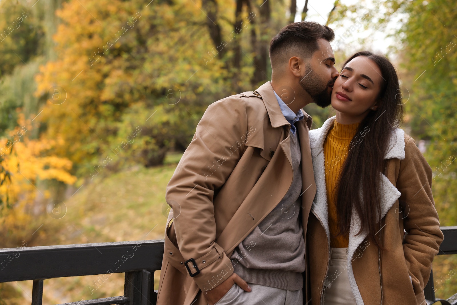 Photo of Romantic young couple spending time together in autumn park, space for text