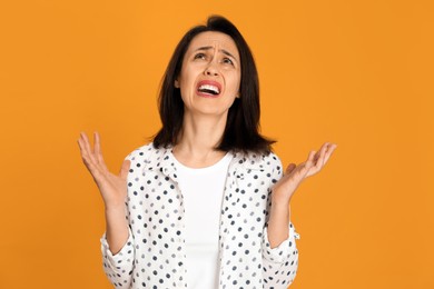 Photo of Portrait of screaming woman filled with hate on yellow background