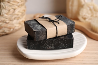 Photo of Natural tar soap on wooden table, closeup