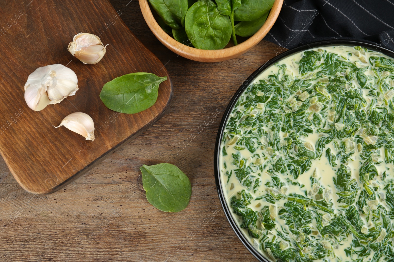 Photo of Tasty spinach dip on wooden table, flat lay