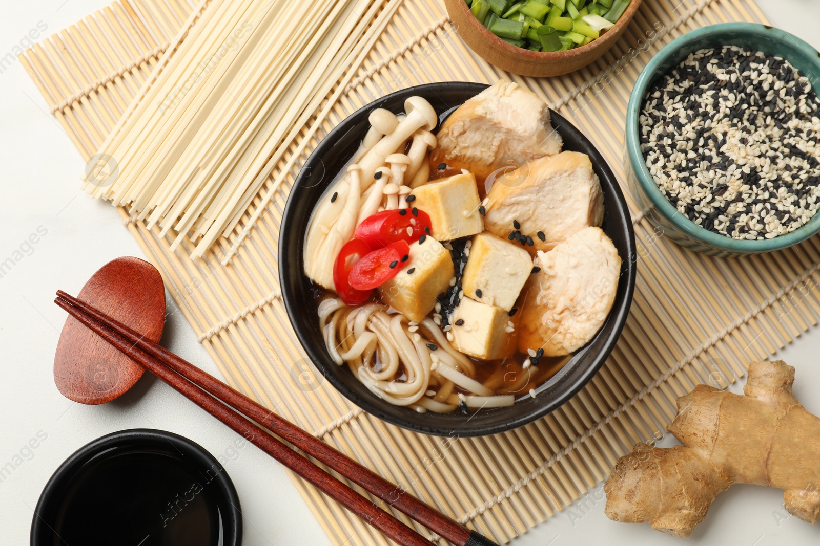 Photo of Delicious ramen served on white table, flat lay. Noodle soup