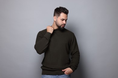 Handsome man in stylish sweater on grey background