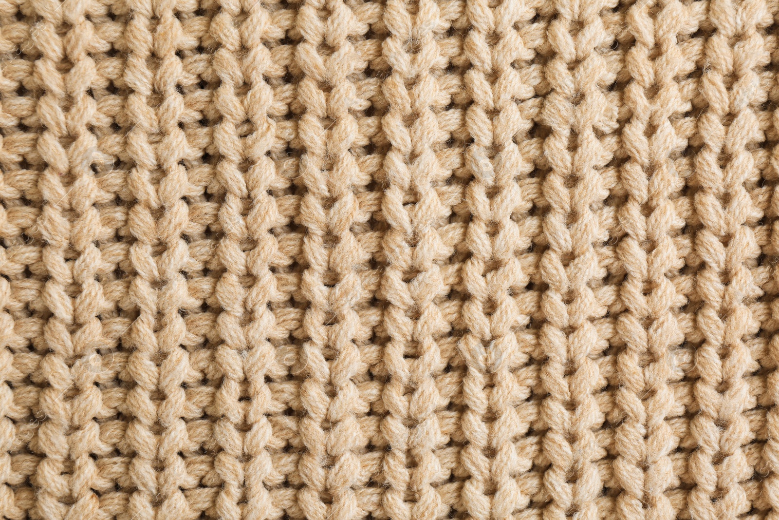 Photo of Beautiful beige knitted fabric as background, top view