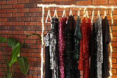 Photo of Collectiondifferent beautiful women's party dresses in showroom. Stylish trendy clothes for high school prom