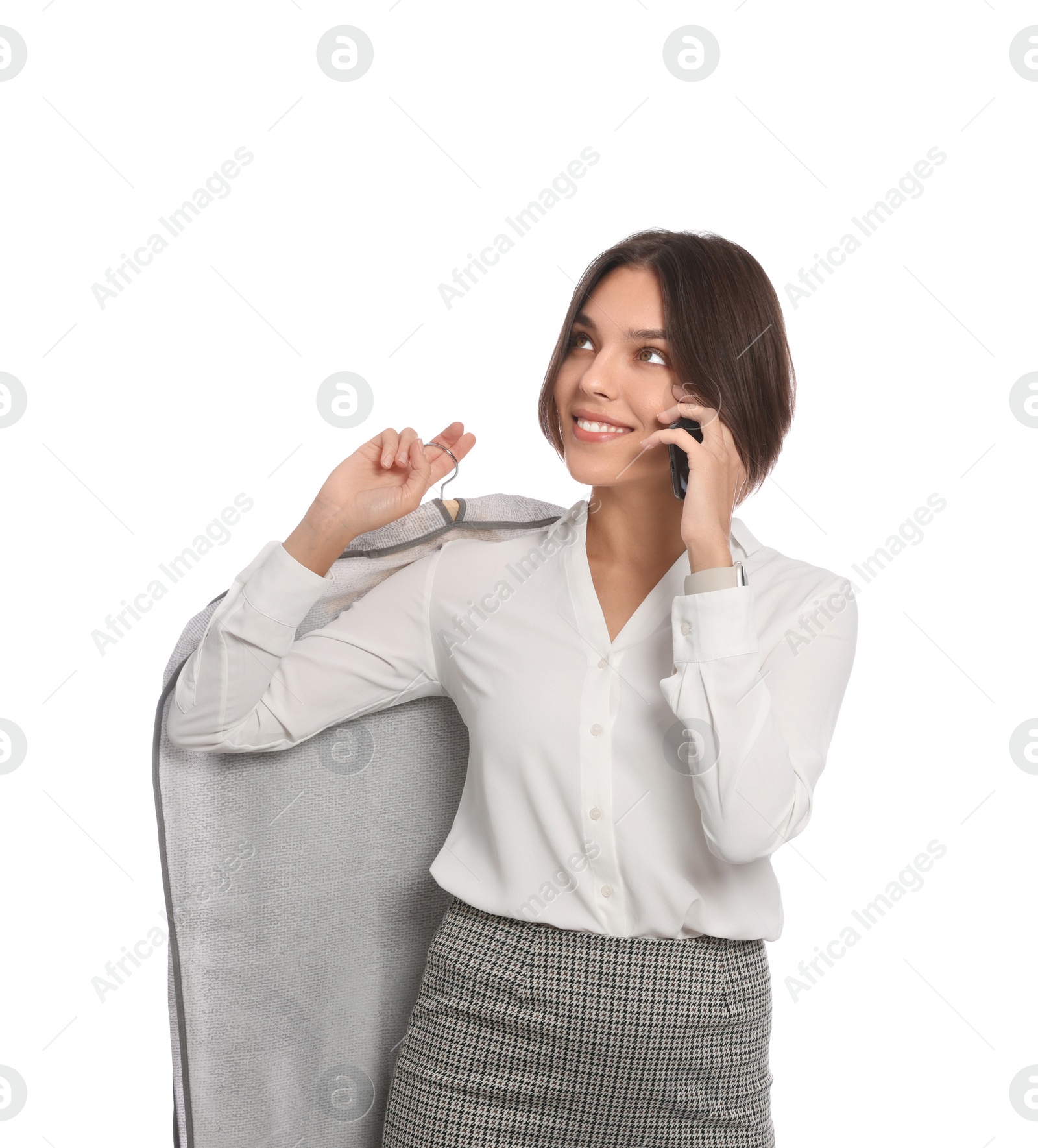 Photo of Woman holding garment cover with clothes while talking on phone, isolated on white. Dry-cleaning service