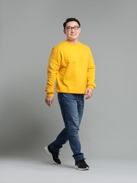 Full length portrait of happy man on grey background