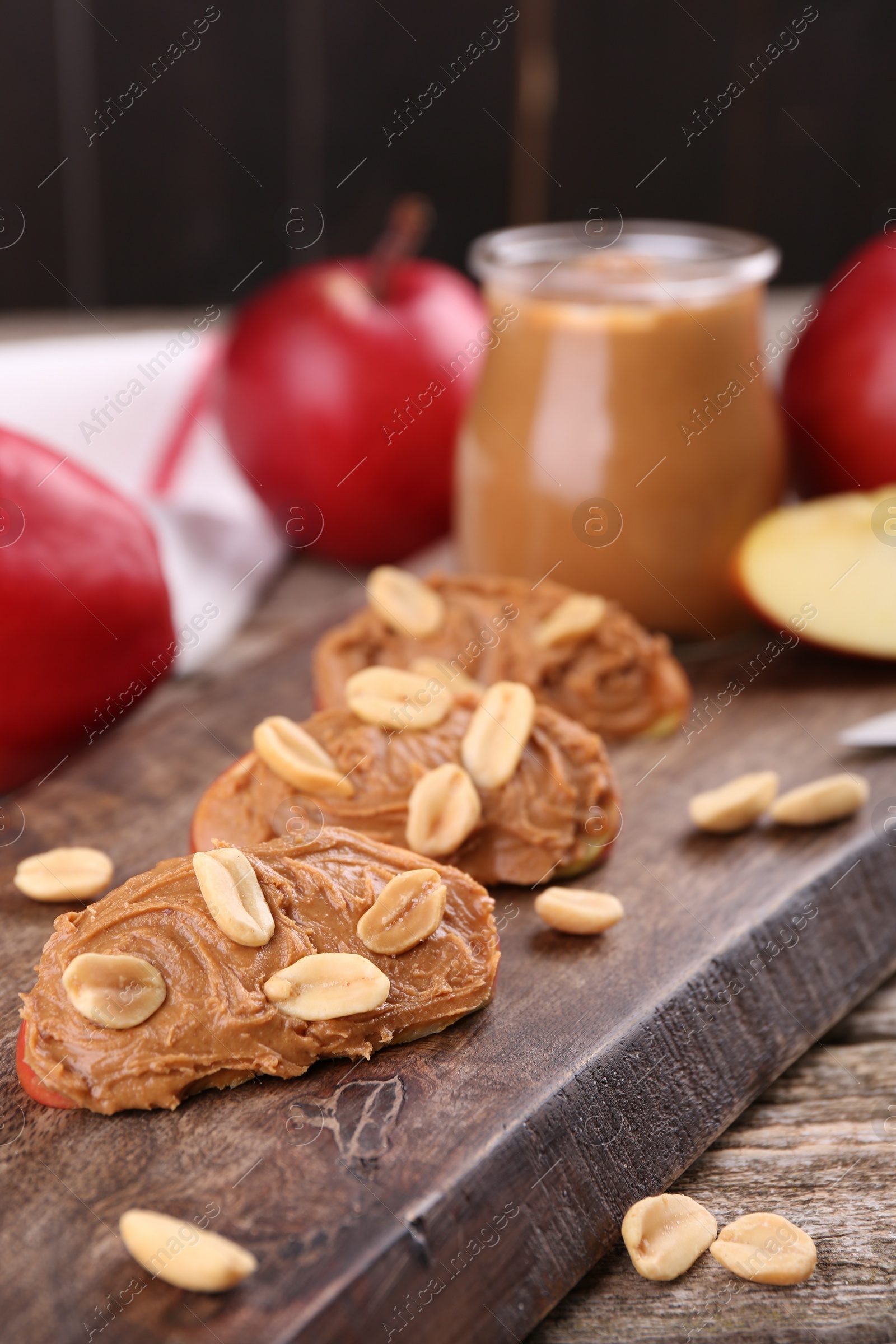 Photo of Pieces of fresh apple with peanut butter on table