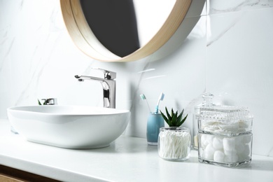 Photo of Cotton balls, pads and swabs on white countertop in bathroom