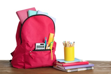 Stylish backpack with school stationery on table against white background