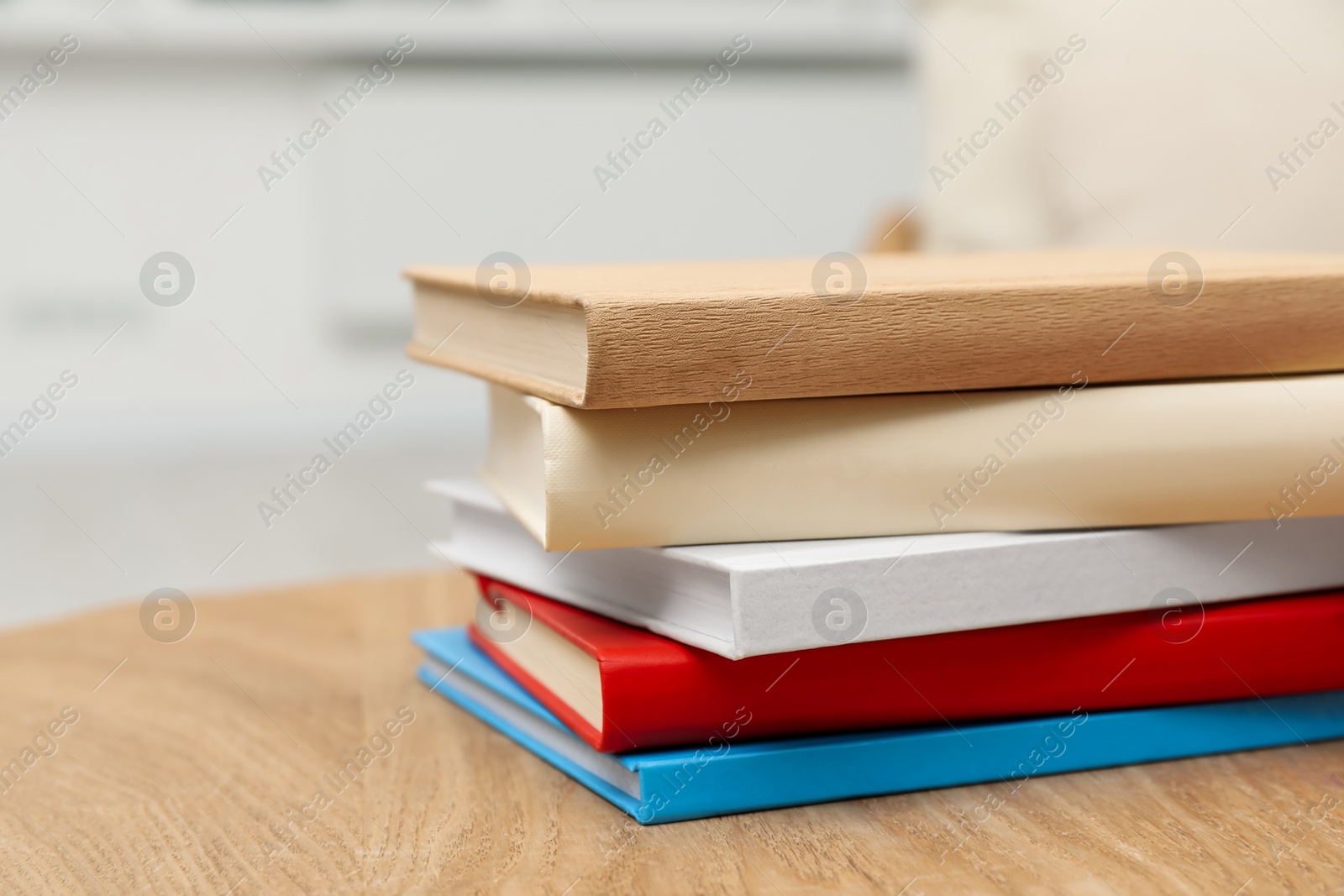 Photo of Stack of hardcover books on wooden table indoors, closeup. Space for text