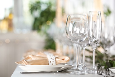 Photo of Table setting with empty glasses, plates and cutlery indoors