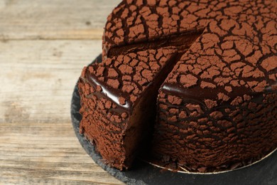 Photo of Delicious chocolate truffle cake on wooden table, closeup