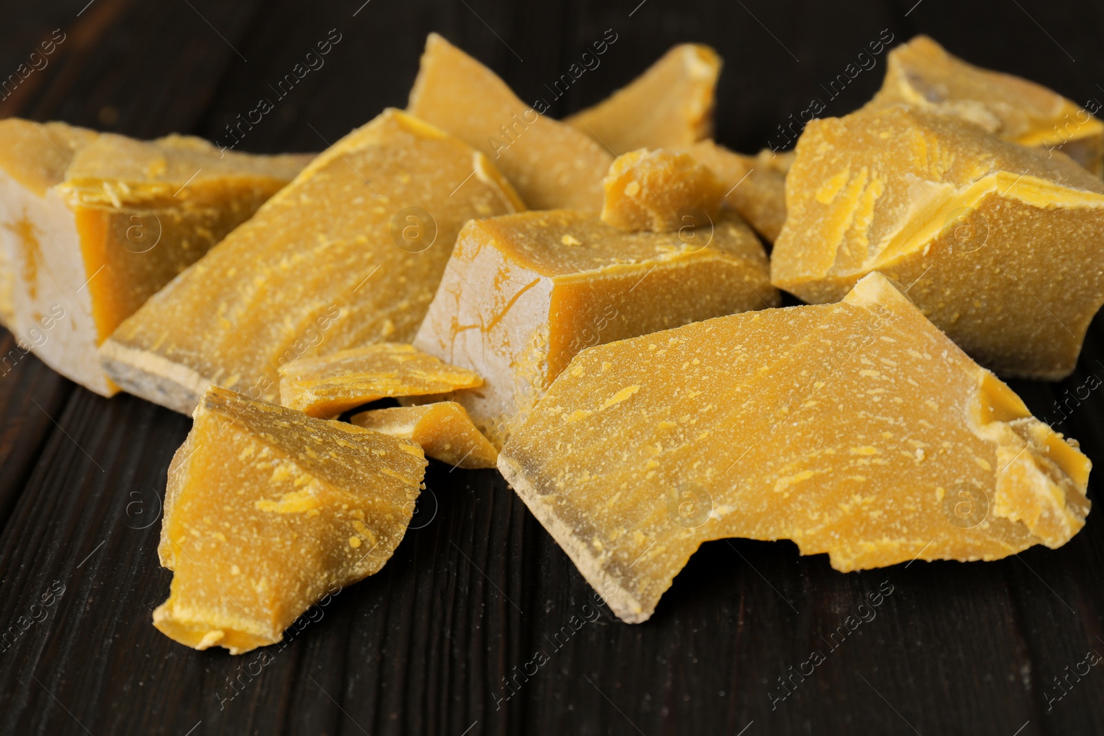 Photo of Natural beeswax blocks on wooden table, closeup