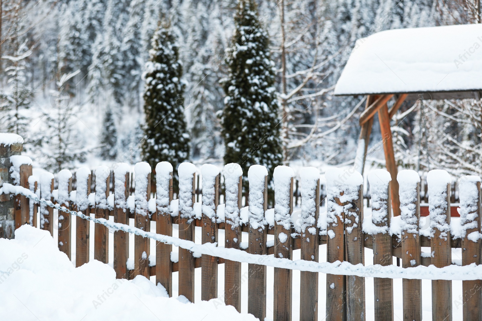 Photo of Wooden fence covered with snow outdoors. Winter vacation