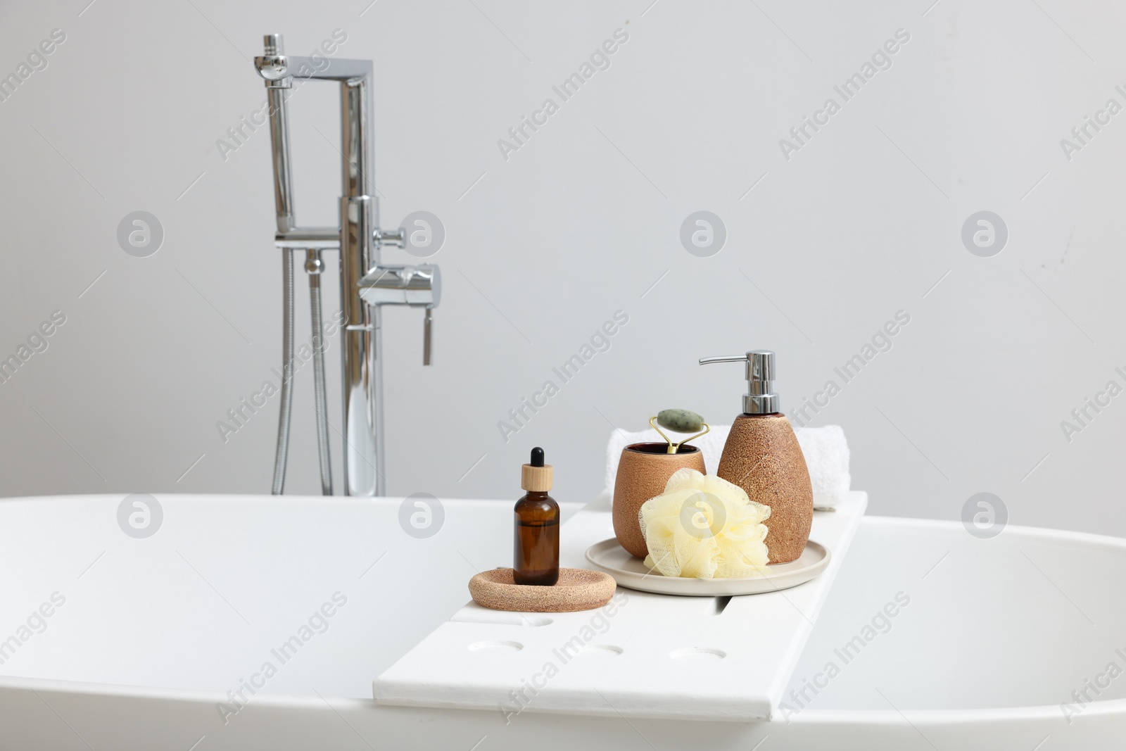 Photo of Different personal care products and accessories on bath tub in bathroom