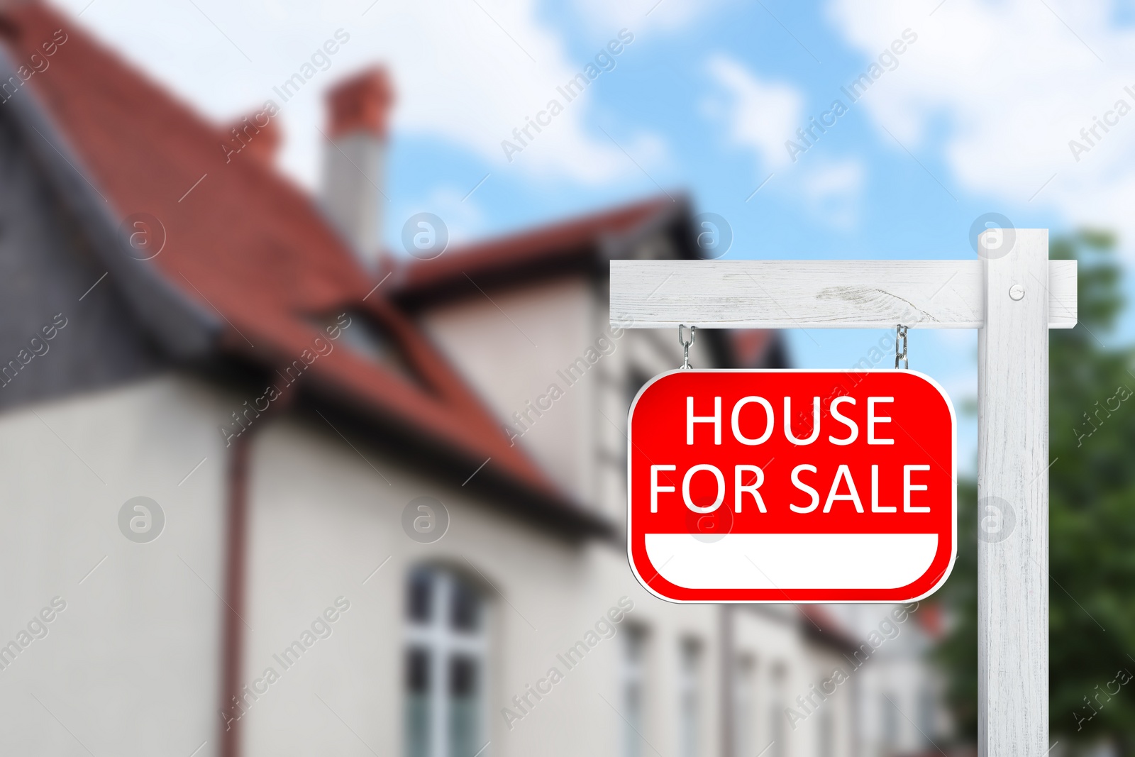 Image of Sale sign near beautiful house outdoors. Red signboard with words