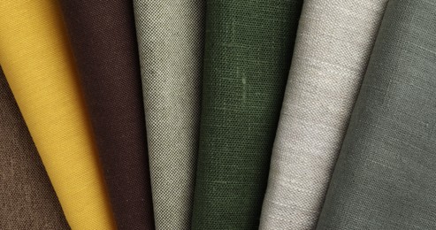 Many different fabrics on brown cloth, top view