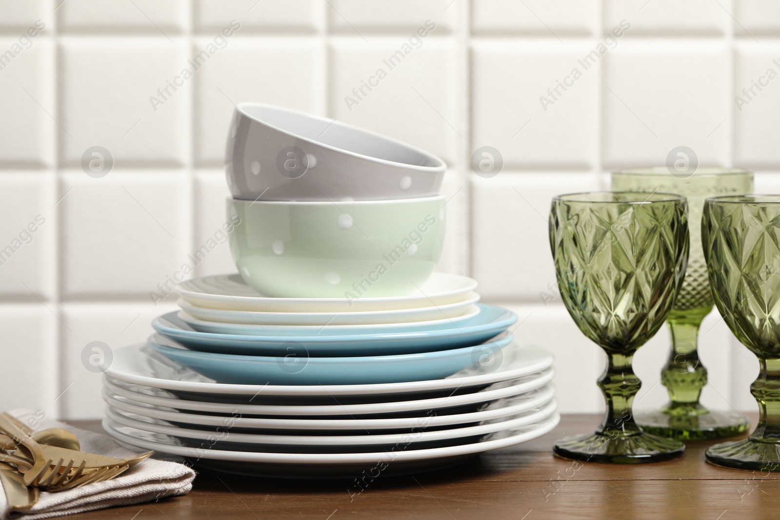 Photo of Beautiful ceramic dishware, glasses and cutlery on wooden table