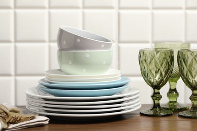 Beautiful ceramic dishware, glasses and cutlery on wooden table