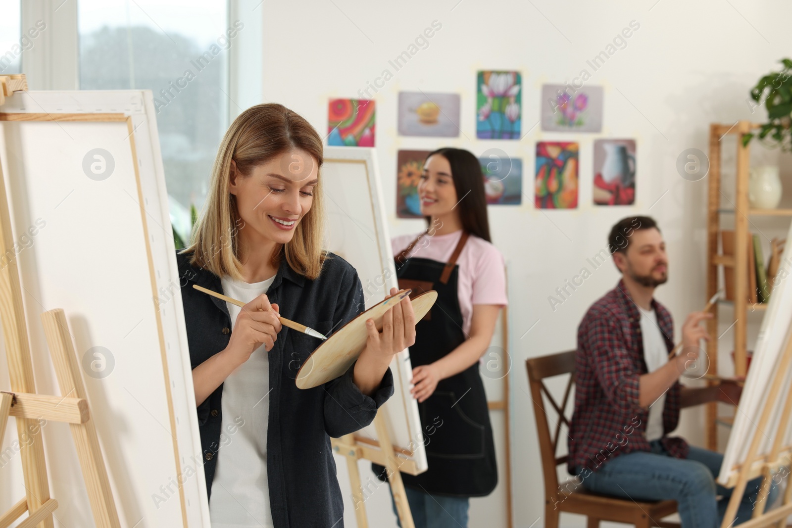 Photo of Group of students attending painting class in studio. Creative hobby