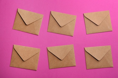 Photo of Brown paper envelopes on purple background, flat lay